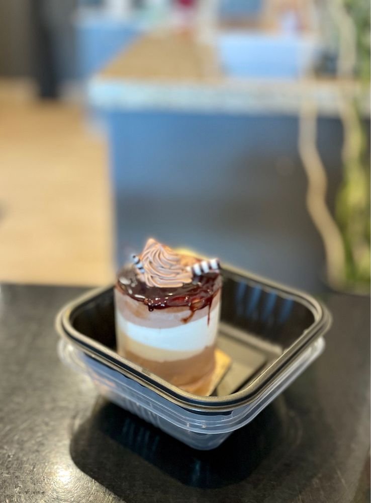 Small layered mousse cake in a to-go container
